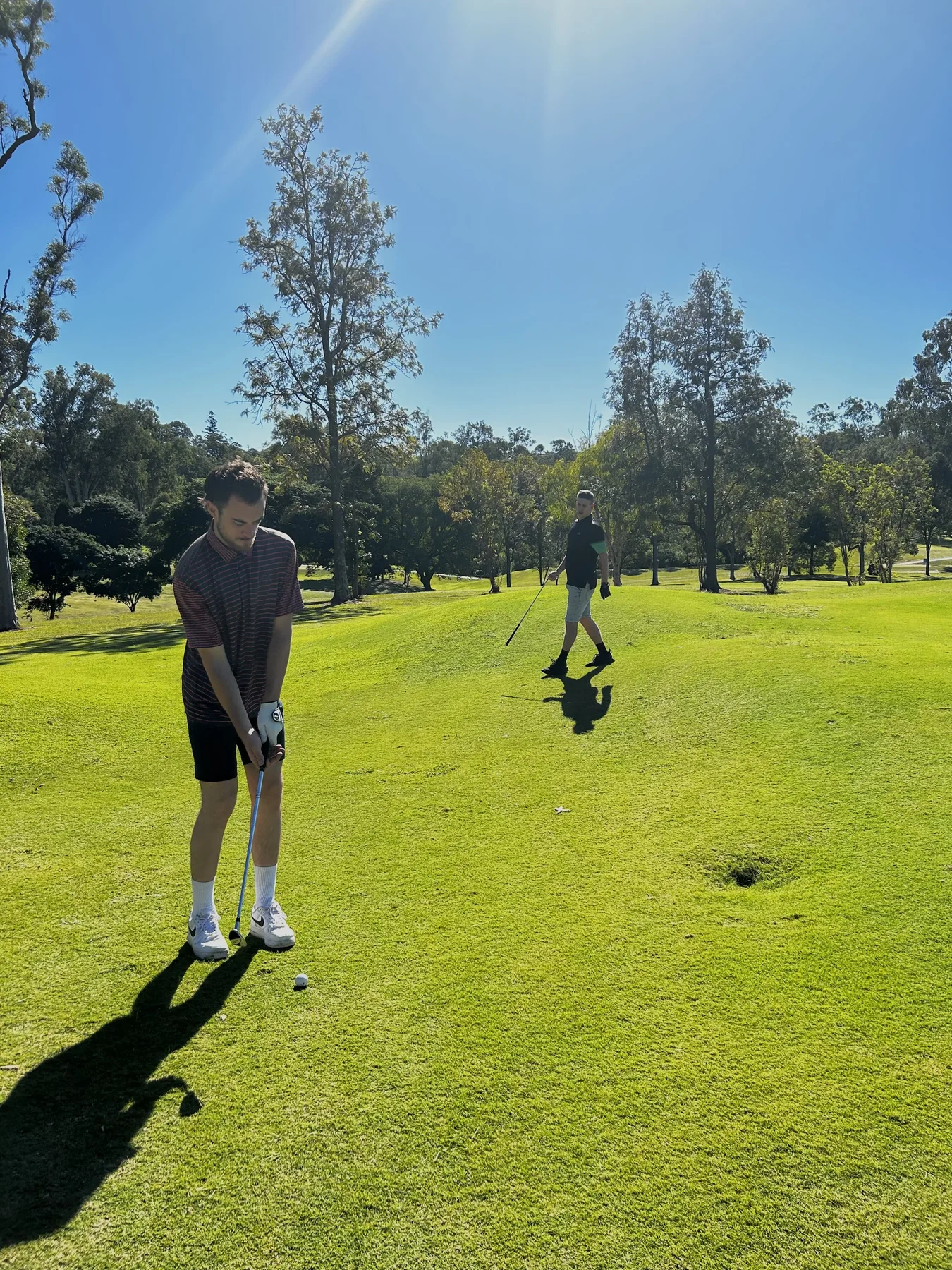 Liam O’Connor taking a golf swing on a sunny golf course